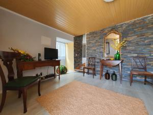 ein Wohnzimmer mit einer Steinmauer und einem Spiegel in der Unterkunft Julia Old Village by Lisbon Village Apartments in Terrugem