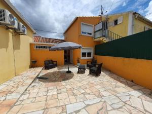 eine Terrasse mit Sonnenschirm vor einem Gebäude in der Unterkunft Julia Old Village by Lisbon Village Apartments in Terrugem