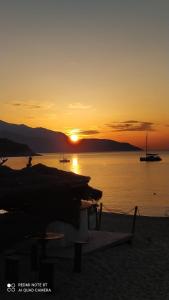 a sunset on the beach with boats in the water at Appartamento Marina in Portoferraio