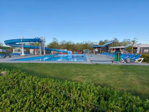 una gran piscina con un tobogán de agua en un parque en Schelde vakantie chalet, en Baarland