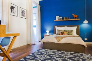um quarto azul com uma cama e uma parede azul em Premium Design Central Suite em Valletta