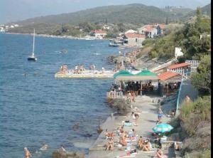 a group of people on a beach near the water at Balkan appartman in Krašići