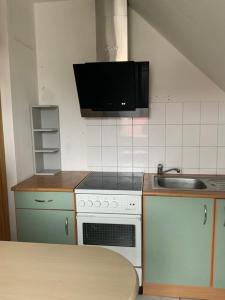 a kitchen with a sink and a stove at Ferien/ Monteurzimmer mit gemeinsam Wozi, Kü, Bad, WLAN in Magdeburg