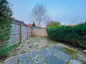 a backyard with a wooden fence and a sidewalk at Home in leeds in Moortown