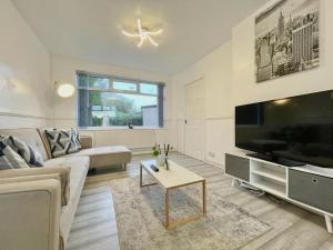 a living room with a large television and a couch at Home in leeds in Moortown