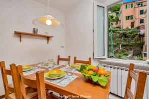 ein Esszimmer mit einem Tisch und einem Fenster in der Unterkunft Ca da Derna in Riomaggiore