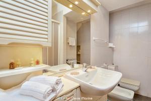 een badkamer met een wastafel, een toilet en een spiegel bij Ca da Derna in Riomaggiore