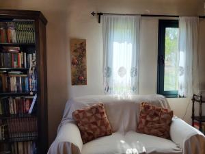 un sofá blanco en una sala de estar con ventana en Vivian's House for relaxing holidays in Nature en Kissamos