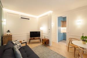 a living room with a couch and a tv at FLH Lapa Apartment with Interior Pateo in Lisbon