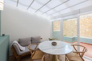 - un salon avec une table, des chaises et un canapé dans l'établissement FLH Lapa Apartment with Interior Pateo, à Lisbonne