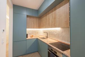 - une cuisine avec des placards bleus et un évier dans l'établissement FLH Lapa Apartment with Interior Pateo, à Lisbonne