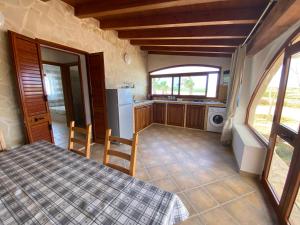 a room with a table and a kitchen with a refrigerator at VILLA CHANTAL in Lampedusa