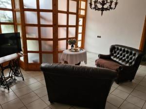 a living room with two leather chairs and a table at Agas Vendeghaz in Csopak