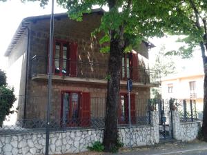 una casa de ladrillo con puertas rojas y una valla en B&B Rosa Dei Venti, en Orvieto