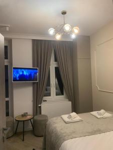 um quarto com uma cama e uma televisão de ecrã plano em MB Boutique Apartment Gdansk em Gdansk