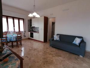 a living room with a blue couch and a table at Villetta Scruscio ri Mare in Favignana