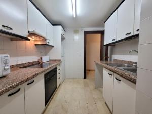 a kitchen with white cabinets and a sink at Santa Margarita-Fincas Benidorm in Benidorm