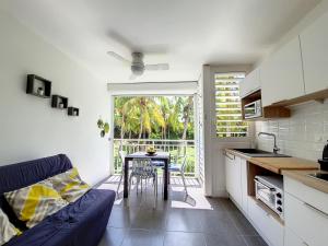 uma cozinha e sala de jantar com uma mesa e um sofá em Studio CocoCaraïbes Anse des Rochers vue mer - piscine em Belle-Allée