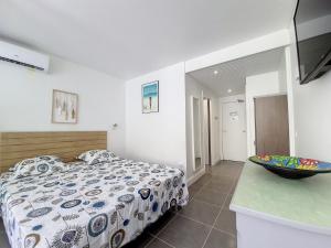 um quarto com uma cama e uma tigela no balcão em Studio CocoCaraïbes Anse des Rochers vue mer - piscine em Belle-Allée mais 43 fotografias