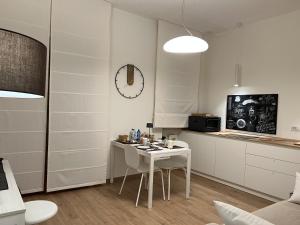 a white kitchen with a table and a microwave at 4B B&B in Fasano +93 photos