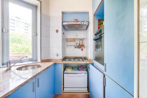a kitchen with blue cabinets and a sink at Note su Puccini 66 in Trieste