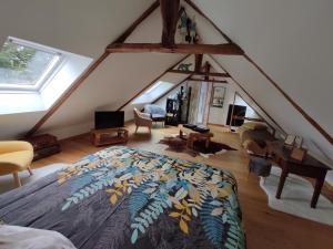 Aux Trois Palmiers في سانت بريوك: غرفة نوم في العلية مع سرير وبطانية ملونة