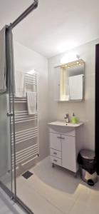 a white bathroom with a sink and a shower at Complex Parc Pini Moinesti in Moineşti