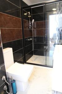 a bathroom with a toilet and a glass shower at Çamlıca Tower Hotel in Istanbul +62 photos