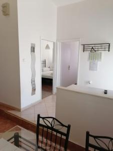 a room with two mirrors and a table and chairs at Apartman Lucija in Murter