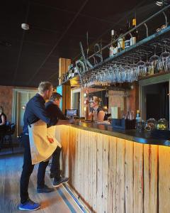 dos hombres parados en un bar en un restaurante en Hotell Temperance, en Hudiksvall