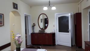 Habitación con espejo, tocador y puerta en Rozalia Apartman, en Gyula