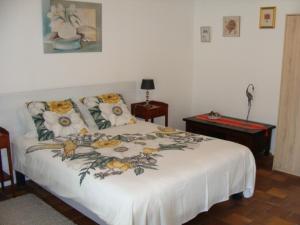 una camera da letto con un letto bianco e fiori di Le Guinguetton Chambre d'hôtes a Prigonrieux