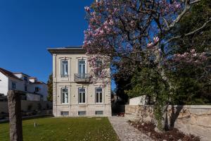 a building with a flowering tree in front of it at Casa Kala in Porto