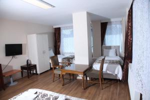 a bedroom with two beds and a desk and a tv at Çamlıca Tower Hotel in Istanbul