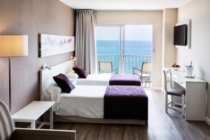 een hotelkamer met een bed en een balkon bij Hotel Brisa Marina in S'Illot