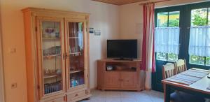 a living room with a television and a cabinet at Haus Lenelies in Prerow
