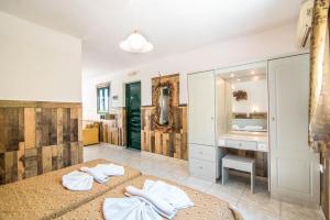 une salle de bain avec un lit, un lavabo et un miroir dans l'établissement Mirage Arillas Studio Type A9, à Arillas