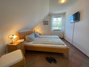 ein kleines Schlafzimmer mit einem Bett und einem Fenster in der Unterkunft Ferienwohnung SÜN in Zingst