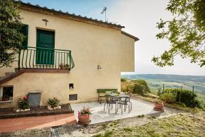 a house with a table and chairs on a patio at La finestra - centro storico Montepulciano, casa panoramica. in Montepulciano