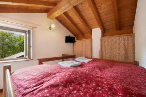 Dosso del LiroにあるLa Fonte di Mariella Monolocale 2のベッドルーム1室(赤い大型ベッド1台、窓付)