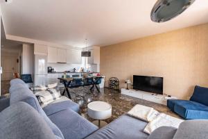 uma sala de estar com sofás azuis e uma cozinha em Casa Annelise em Fuengirola