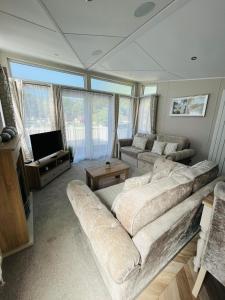 uma sala de estar com dois sofás e uma televisão em The Braunston Lodge with Hot Tub em York