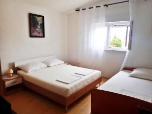 スタリグラードにあるApartments Darijaの窓のある小さな部屋にベッドが2つある