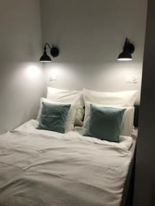 a white bed with two pillows and two lights above it at Apartament Bulvar Starówka in Elblag