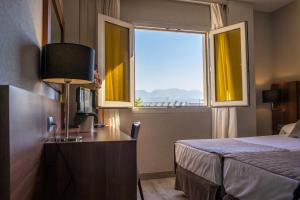 Habitación de hotel con cama y ventana en BS Principe Felipe en Albolote