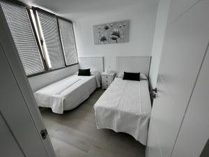a bedroom with two beds and a window at Arrecife exclusive beach house in Arrecife