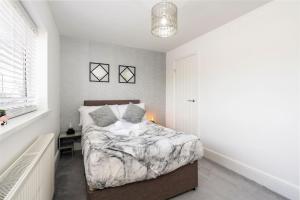 a bedroom with a bed and a window at Modern Contractor House & Free Parking & Garden in Hull