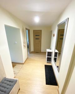 a room with a hallway with a mirror and a couch at MARCO Apartment 8 in Giżycko