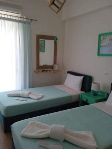 Villazia Exclusive Estate في Episkopianá: غرفة نوم بسريرين ومرآة