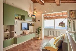 a living room with a couch and a tv at La finestra - centro storico Montepulciano, casa panoramica. in Montepulciano